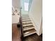 Elegant staircase with wooden steps, a white banister, and decorative shelving at 5090 Bellehurst Ln, Cumming, GA 30040