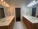 Bright bathroom featuring dual sinks, wood cabinets, and tile floors at 100 Hamilton Glen Ct, Fayetteville, GA 30215