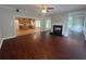 Open concept living room with hardwood floors, fireplace and kitchen view at 100 Hamilton Glen Ct, Fayetteville, GA 30215