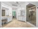 Bright bathroom with double vanity, walk-in glass shower, chandelier, and tile floors at 1045 River Pt, Suwanee, GA 30024
