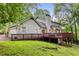 Back exterior view of the home, with a walkout deck and wooded backyard at 2240 Six Branches Dr, Roswell, GA 30076