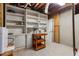 View of basement with painted brick wall, built in shelving, and a wooden cart at 2240 Six Branches Dr, Roswell, GA 30076