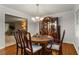 Cozy dining room with hardwood floors, chandelier, and a wooden table with seating for six at 2240 Six Branches Dr, Roswell, GA 30076