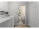 Bright laundry room with modern washer and dryer, leading into a toilet room, and an 'Attic Storage' closet at 2240 Six Branches Dr, Roswell, GA 30076