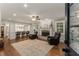 Bright living room with fireplace, hardwood floors, ceiling fan, and an open view to the kitchen at 2240 Six Branches Dr, Roswell, GA 30076