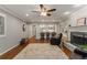 Comfortable living room featuring hardwood floors, fireplace, ceiling fan, and a seamless flow to the kitchen at 2240 Six Branches Dr, Roswell, GA 30076