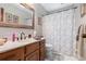 Well-lit bathroom featuring a granite countertop, wood vanity, and classic framed mirror at 4782 Donnegal Se Ct, Mableton, GA 30126