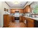 Well-lit kitchen with granite countertops, stainless steel appliances, and wooden cabinets and flooring at 4782 Donnegal Se Ct, Mableton, GA 30126