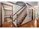 Traditional staircase with carpeted steps and wood railing, adjacent to hardwood floors at 4782 Donnegal Se Ct, Mableton, GA 30126