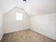 Attic area with carpet flooring and small window at 558 Olympic Way, Acworth, GA 30102