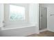 Bathroom featuring a soaking tub under a window and a separate glass shower at 558 Olympic Way, Acworth, GA 30102