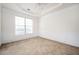 Well-lit empty bedroom boasts decorative molding, neutral carpet, and a large window at 558 Olympic Way, Acworth, GA 30102