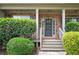 Inviting front entrance with a stylish gray door, brick surround, and manicured shrubbery at 558 Olympic Way, Acworth, GA 30102