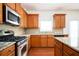 Modern kitchen with stainless steel appliances, wooden cabinets, and a tiled backsplash at 558 Olympic Way, Acworth, GA 30102