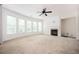 Open living room with neutral carpet, fireplace, and ample natural light from the wall of windows at 558 Olympic Way, Acworth, GA 30102