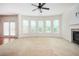 Bright living room with a ceiling fan, fireplace, and large windows offering a view of the outdoors at 558 Olympic Way, Acworth, GA 30102