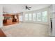 Bright living room featuring carpeted floors, fireplace, ceiling fan and a wall of windows at 558 Olympic Way, Acworth, GA 30102