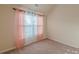 Cozy bedroom featuring neutral walls, plush carpet, and soft, natural light through the window at 879 Tranquil Way, Hampton, GA 30228