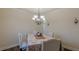 Traditional dining room with seating for four under a chandelier at 879 Tranquil Way, Hampton, GA 30228