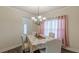 Dining room with modern chandelier and seating for four near a large bright window at 879 Tranquil Way, Hampton, GA 30228