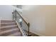 Elegant staircase with carpeted steps and a dark wooden railing; natural light filters in at 879 Tranquil Way, Hampton, GA 30228