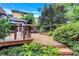 Landscaped backyard featuring a wood deck with stone steps and lush foliage at 935 Cumberland Ne Rd, Atlanta, GA 30306