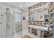 Modern bathroom with a glass-enclosed shower, double vanity, and patterned accent wall at 935 Cumberland Ne Rd, Atlanta, GA 30306