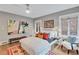 Bright bedroom with a large bed and windows, neutral walls, and a colorful abstract artwork at 935 Cumberland Ne Rd, Atlanta, GA 30306