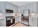 Well-lit kitchen featuring white cabinets, subway tile backsplash, and stainless steel appliances for modern cooking at 935 Cumberland Ne Rd, Atlanta, GA 30306