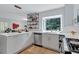 Bright kitchen features white cabinets, stainless appliances, and a large window overlooking lush greenery at 935 Cumberland Ne Rd, Atlanta, GA 30306