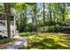 Lush backyard with a stone path leading to a well-manicured lawn and wooded area at 2375 Hyde Park Nw Ct, Atlanta, GA 30318