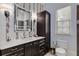 Bathroom features tile accent wall, dark cabinets, and a large mirror at 2375 Hyde Park Nw Ct, Atlanta, GA 30318