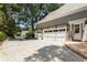 Spacious three-car garage with an extended driveway and mature trees at 2375 Hyde Park Nw Ct, Atlanta, GA 30318