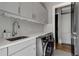 Bright laundry room featuring modern washer and dryer, ample counter space, and stylish cabinets at 2375 Hyde Park Nw Ct, Atlanta, GA 30318