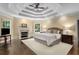 Bright primary bedroom features fireplace, sitting area, ceiling fan, and hardwood floors at 2375 Hyde Park Nw Ct, Atlanta, GA 30318