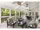 Inviting sunroom with comfortable seating, ceiling fans, and views of the surrounding greenery at 2375 Hyde Park Nw Ct, Atlanta, GA 30318