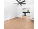 Spacious living room with hardwood floors, neutral walls, and a ceiling fan that flows into the modern kitchen at 264 Howell Sw Ter, Atlanta, GA 30331