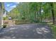 Home with large driveway leading to a spacious backyard with mature trees and a basketball hoop at 2095 Honeysuckle Dr, Cumming, GA 30040