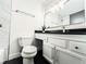 Updated bathroom boasts sleek black countertops, modern fixtures, and decorative wall mirror at 3150 Stratford Green Pl, Avondale Estates, GA 30002