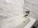 Comfortable bathtub with a modern finish, surrounded by white and gray marble tile at 3150 Stratford Green Pl, Avondale Estates, GA 30002