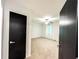 A neutral bedroom viewed through a dark door, featuring carpet floors and a ceiling fan at 3150 Stratford Green Pl, Avondale Estates, GA 30002