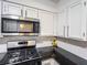 A kitchen featuring stainless steel appliances, white cabinets, gas range and black countertops at 3150 Stratford Green Pl, Avondale Estates, GA 30002