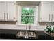 Double basin sink sits beneath a window with backyard view at 3150 Stratford Green Pl, Avondale Estates, GA 30002