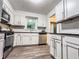 Bright kitchen featuring white cabinets, wood floors, stainless steel appliances, and black countertops at 3150 Stratford Green Pl, Avondale Estates, GA 30002