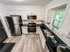 Bright kitchen features stainless steel appliances, granite countertops, and natural light from the window at 3150 Stratford Green Pl, Avondale Estates, GA 30002
