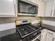 Kitchen view featuring gas range, black countertops, white cabinets, subway tile backsplash and lemons at 3150 Stratford Green Pl, Avondale Estates, GA 30002