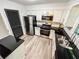 Kitchen features stainless steel appliances, white cabinetry, modern backsplash, and gray wood-look flooring at 3150 Stratford Green Pl, Avondale Estates, GA 30002