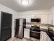 Updated kitchen features stainless steel appliances, white cabinets, black countertops, and modern fixtures at 3150 Stratford Green Pl, Avondale Estates, GA 30002
