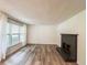 Bright living room features wood-look floors, a fireplace, and a large window with curtains at 3150 Stratford Green Pl, Avondale Estates, GA 30002