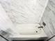 Close up of a shower tub with a white shower curtain and marble tiled walls at 3150 Stratford Green Pl, Avondale Estates, GA 30002